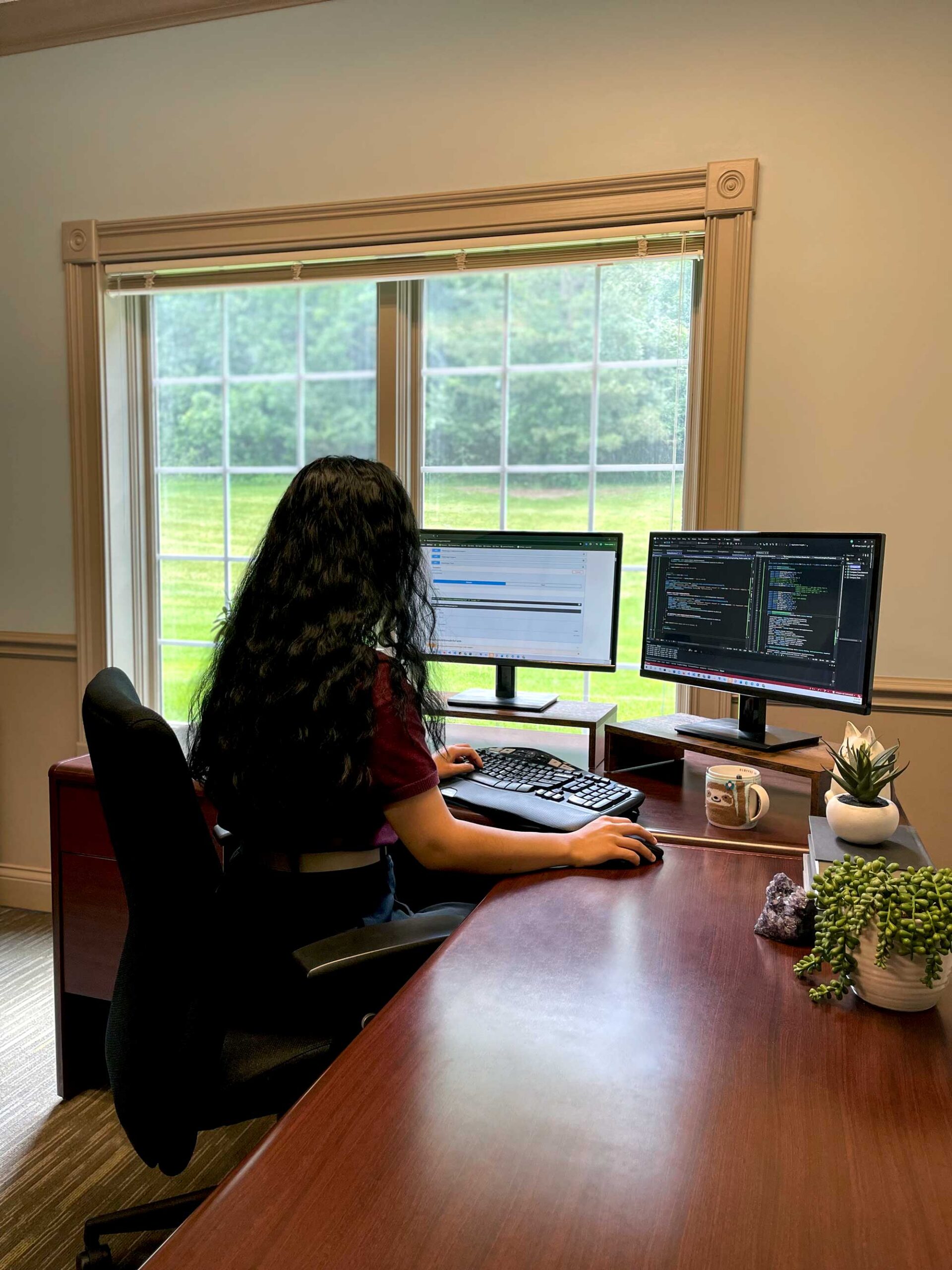 Female software developer working on code at her desk at the Lanex office in Hartland WI.