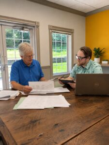 Two Lanex team members reviewing project diagrams and discussing software requirements during a planning meeting.
